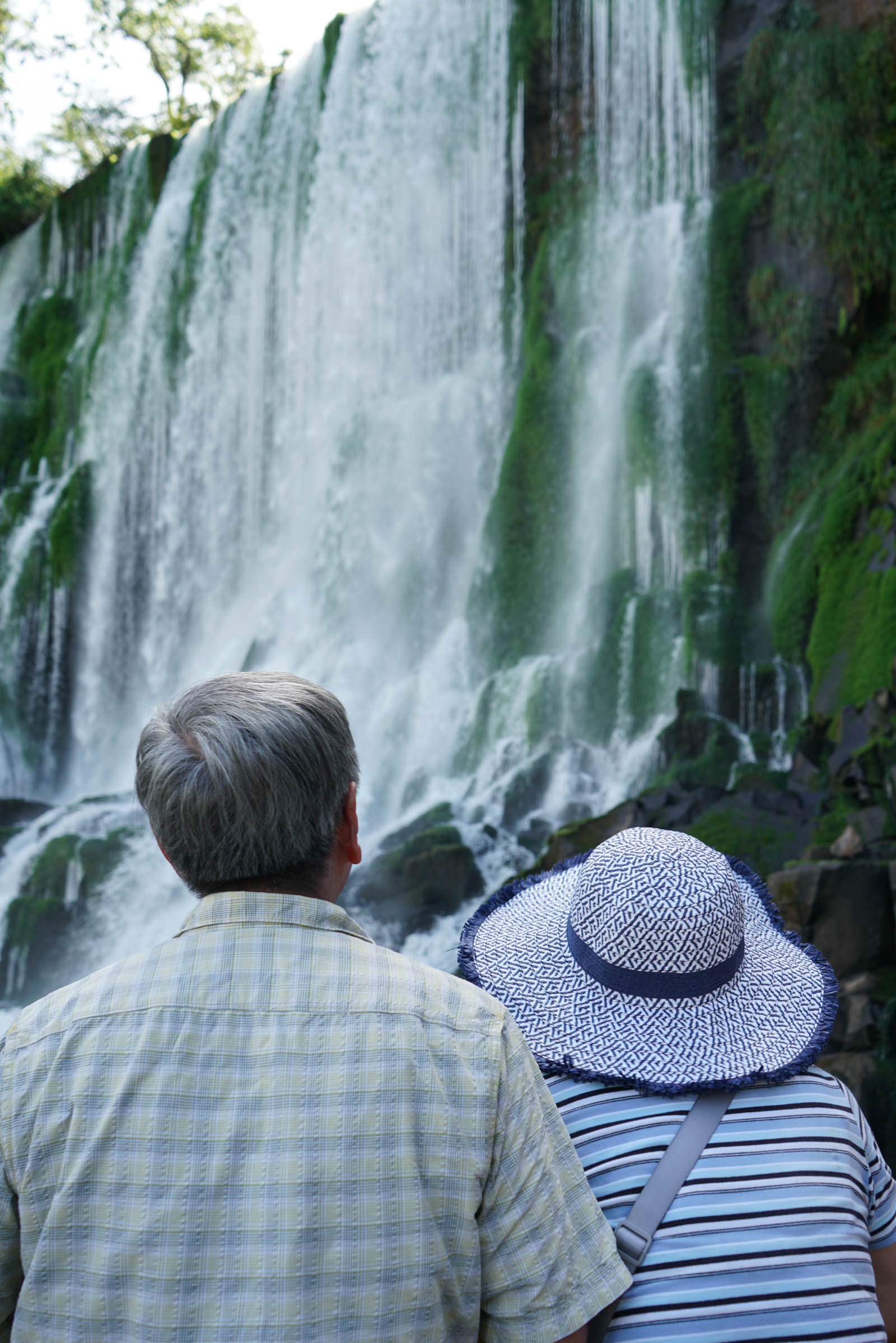 The Hsus admiring a waterfall and the cool mist from up close
